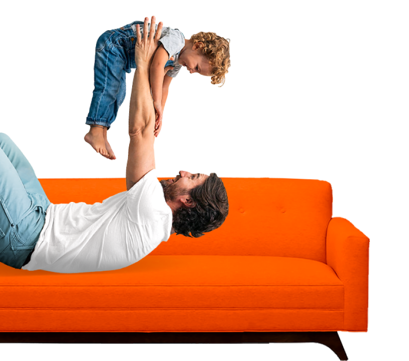 A man on a sofa playfully lifts up a smiling child